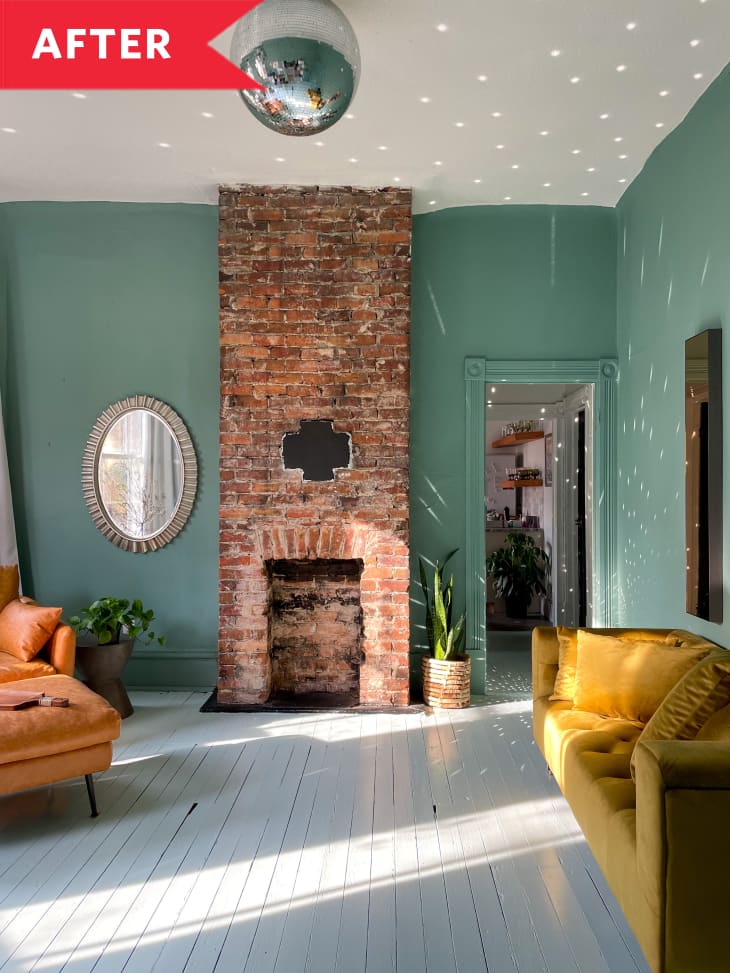 After: Living room with large brick fireplace, green walls, yellow sofa, leather armchair, and disco ball hanging overhead