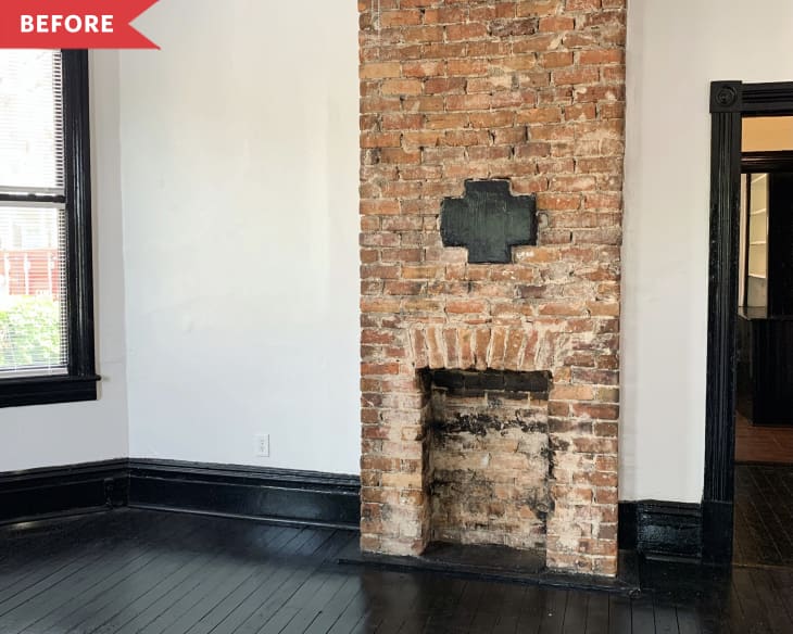 Before: Floor-to-ceiling brick fireplace in room with white walls and black floors and trim