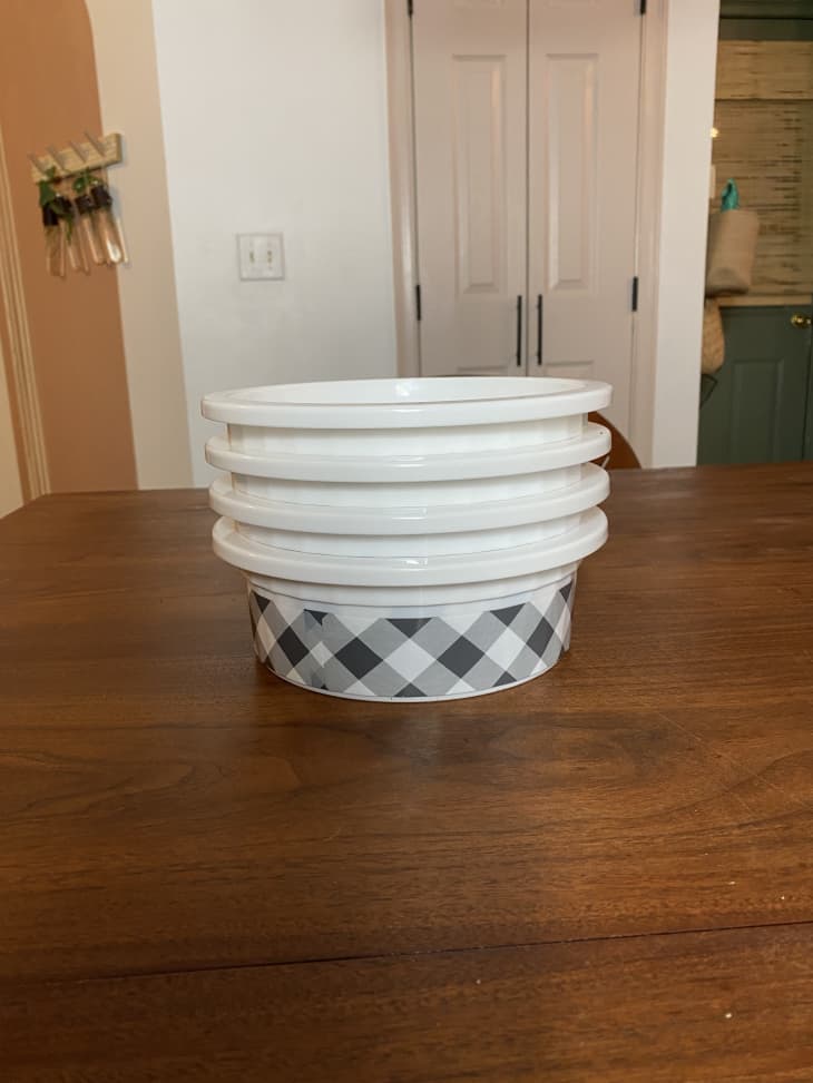 Stack of white dog bowls with gray gingham pattern on the sides