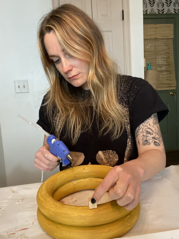 Hot gluing wood blocks to base of ring stack (painted gold)