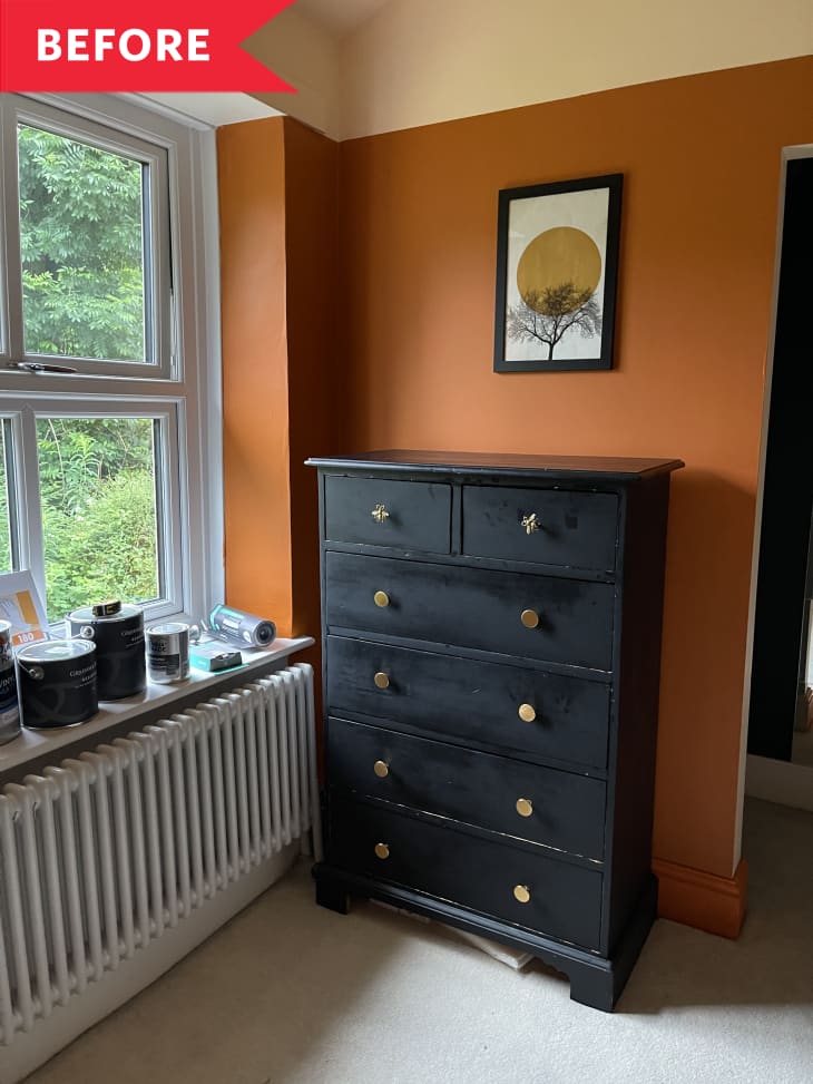 Before: Black dresser in room with orange walls