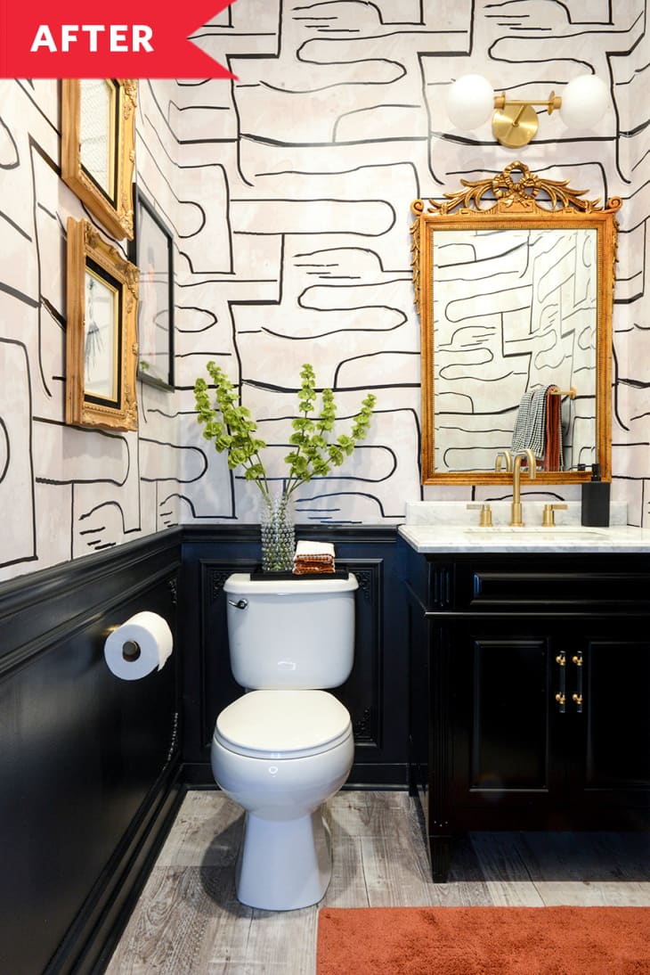 后:浴室与黑色的梳妆台，黑色的造型，金色的镜子和框架，和黑白壁纸