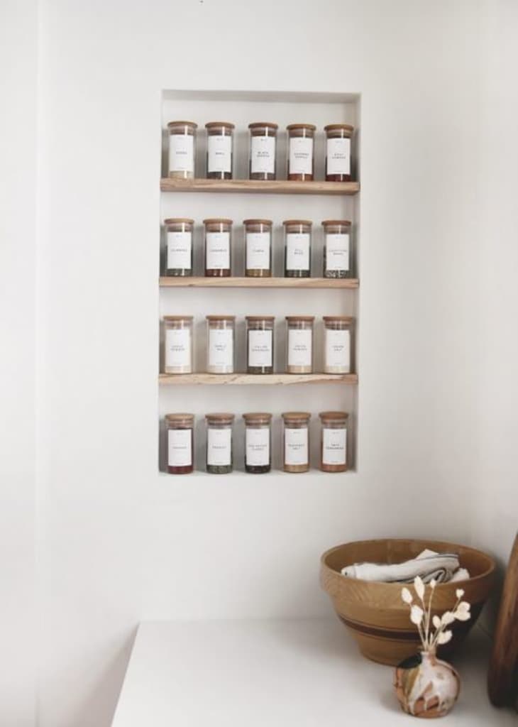 wall of spices in jars, with minimalist white labels