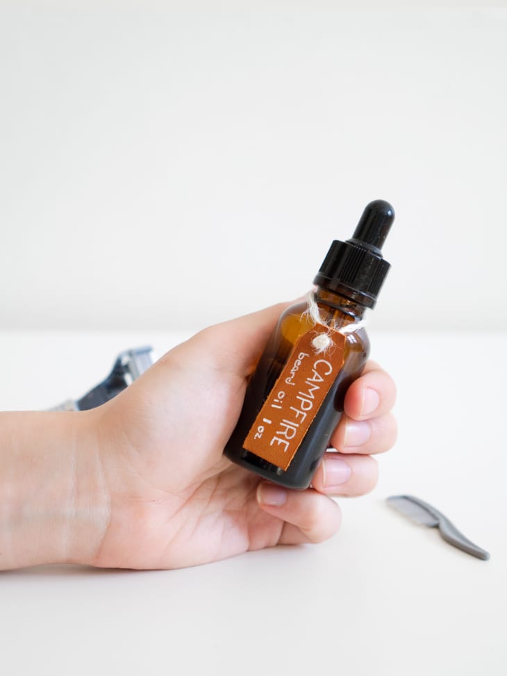 hand holding a small bottle of beard oil
