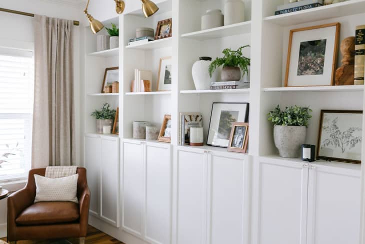Wall of built-in white bookcases made from IKEA BILLY bookcases