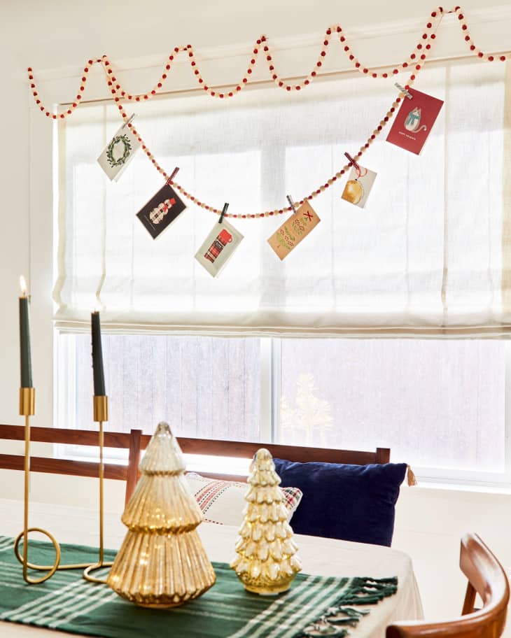 Cards hanging from a beaded garland in front of a window