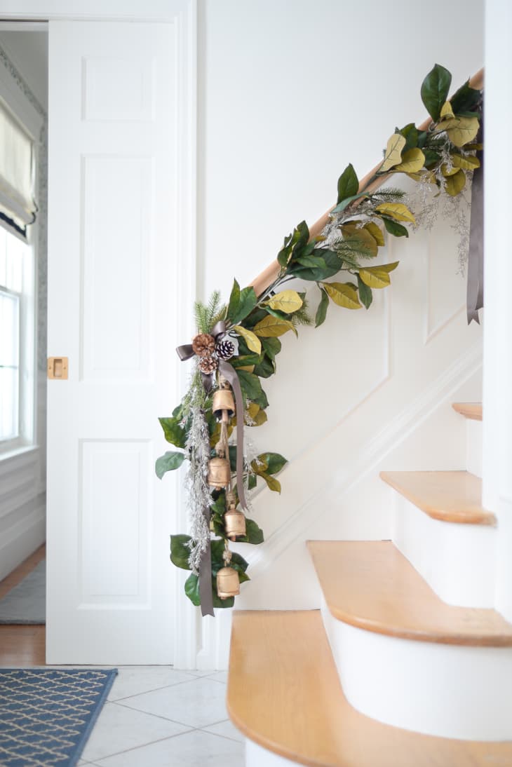 Garland with bells and bows attached to stair railing