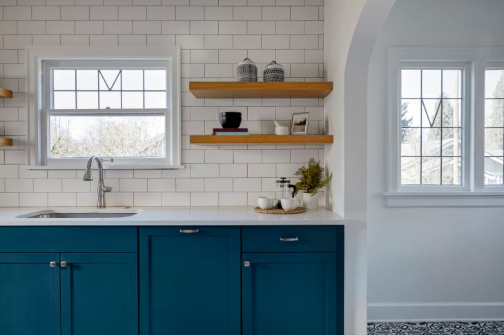 kitchen with bright blue painted base cabinets and open wood shelves