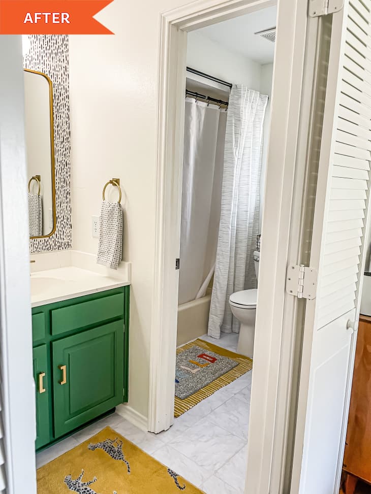 Bathroom with green cabinets going into shower entry