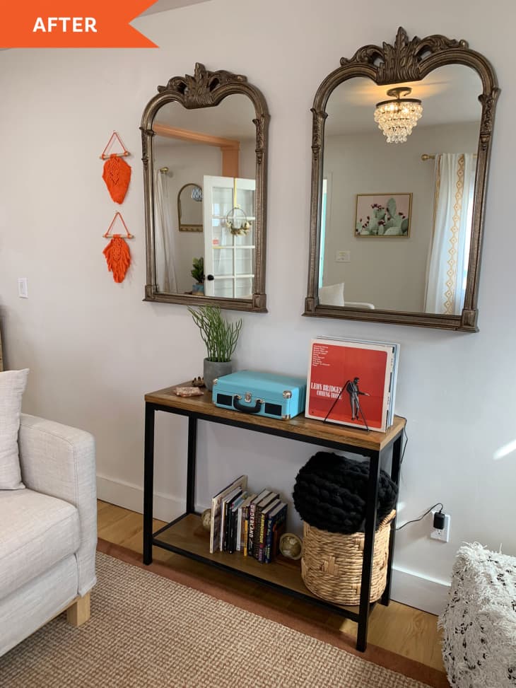After: wall of living room featuring two hanging mirrors