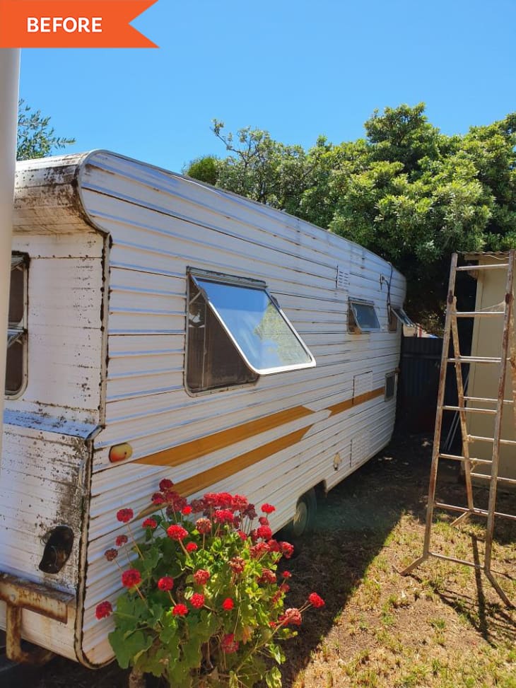 Before: Exterior of RV with white siding with two oranges stripes