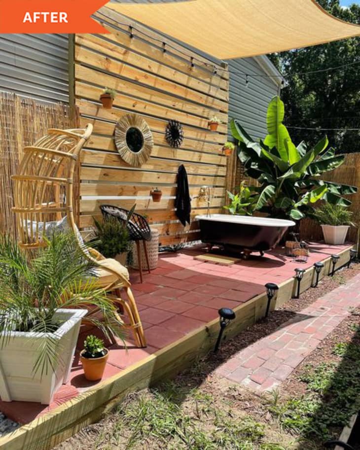 After: outdoor patio space with wooden wall and tub