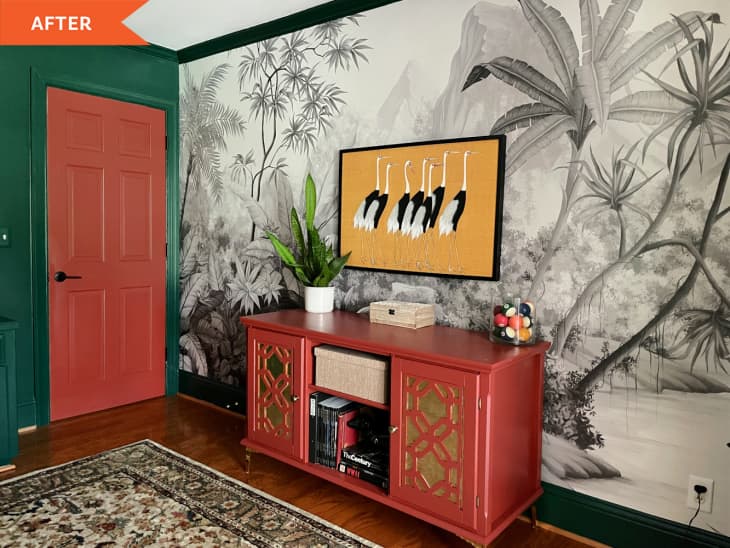 After: tropical black and white wallpaper with bird painting on top above a red and gold dresser