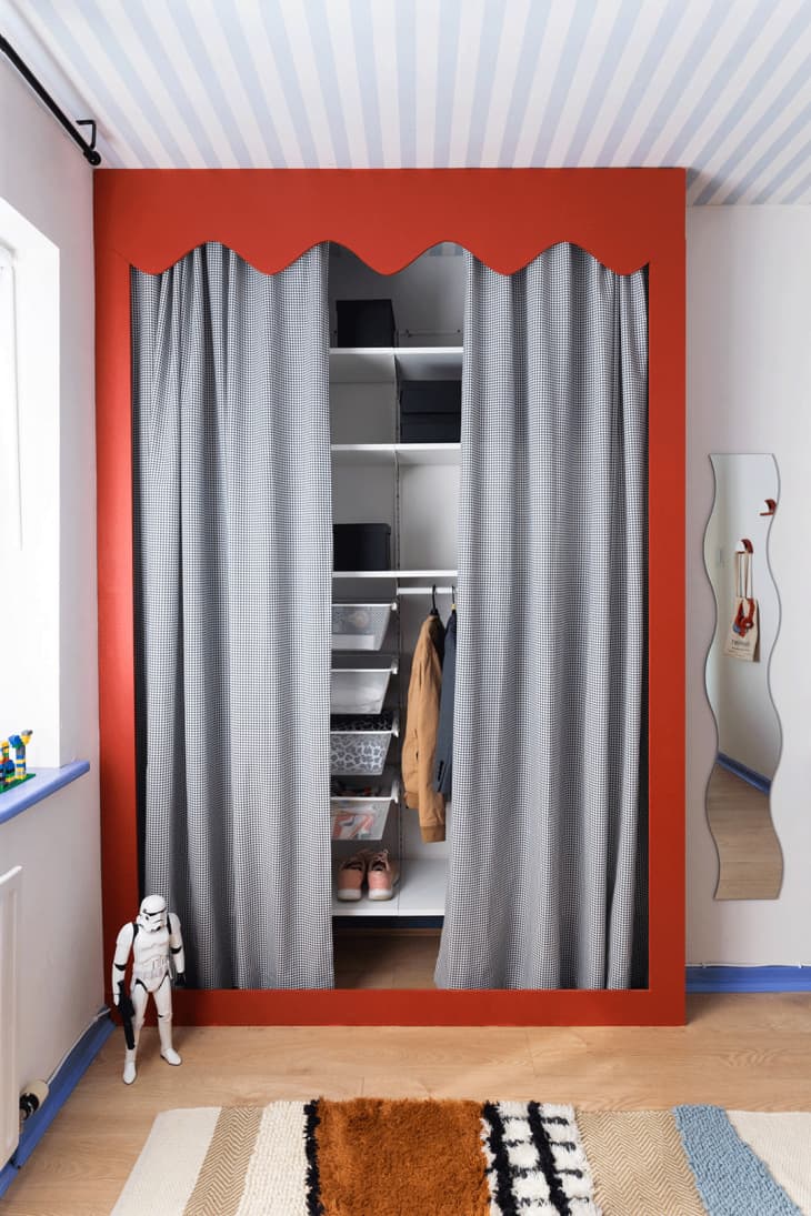 Kid's closet with a red frame and gray curtain in front