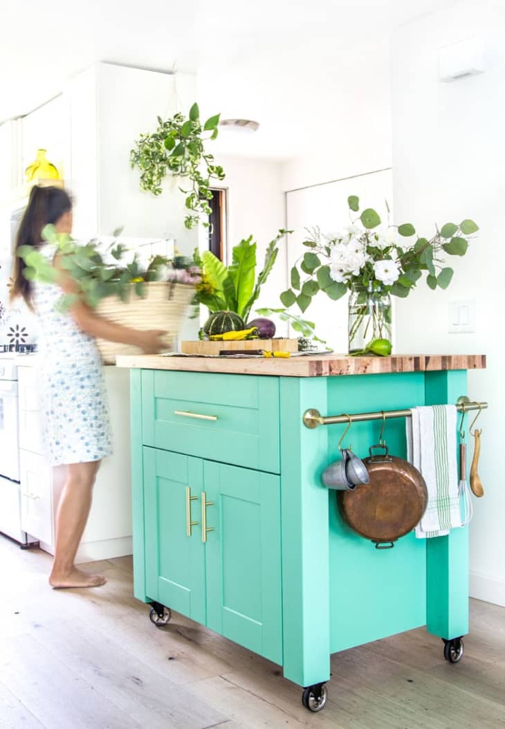 Kitchen island on wheels, with base painted bright teal and top natural wood