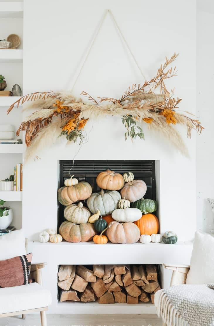 A white mantel filled with pumpkins