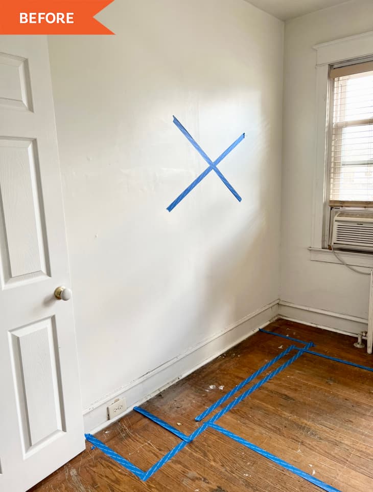 Before: white wall with blue painters tape on wall and floor