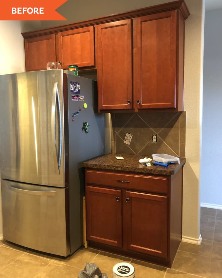 Before: Fridge surrounded by dark brown cabinets