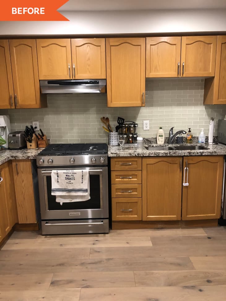 Before: light brown cabinets in kitchen next to stainless steel stove