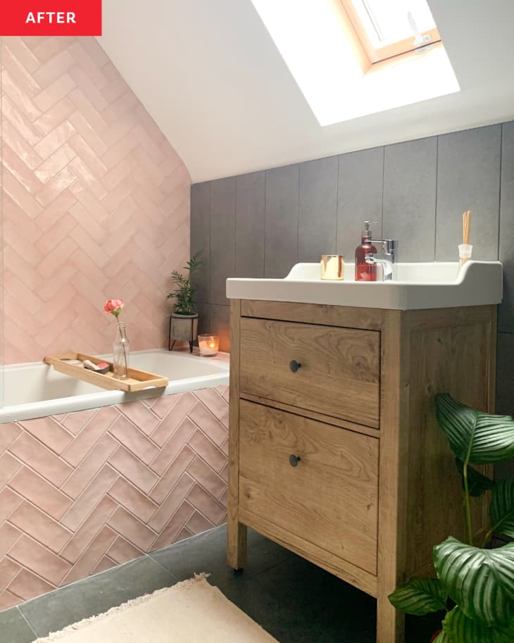 After: a pink tiled bathtub next to a wooden sink