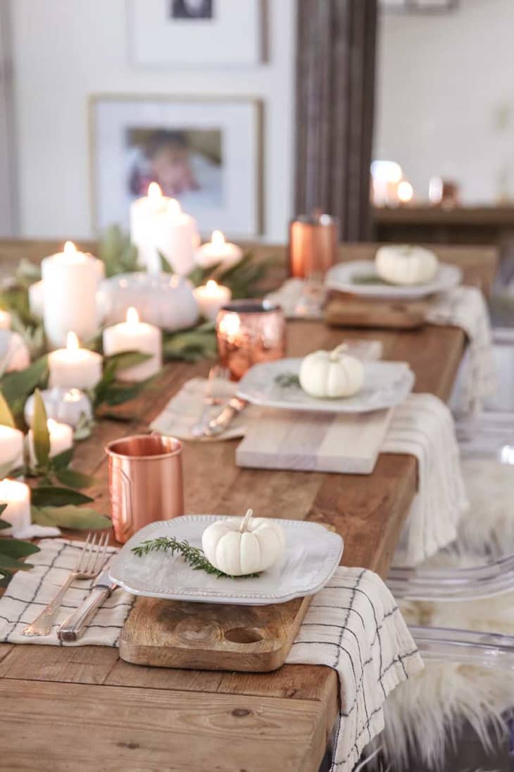 A dining table with candles at the centerpiece