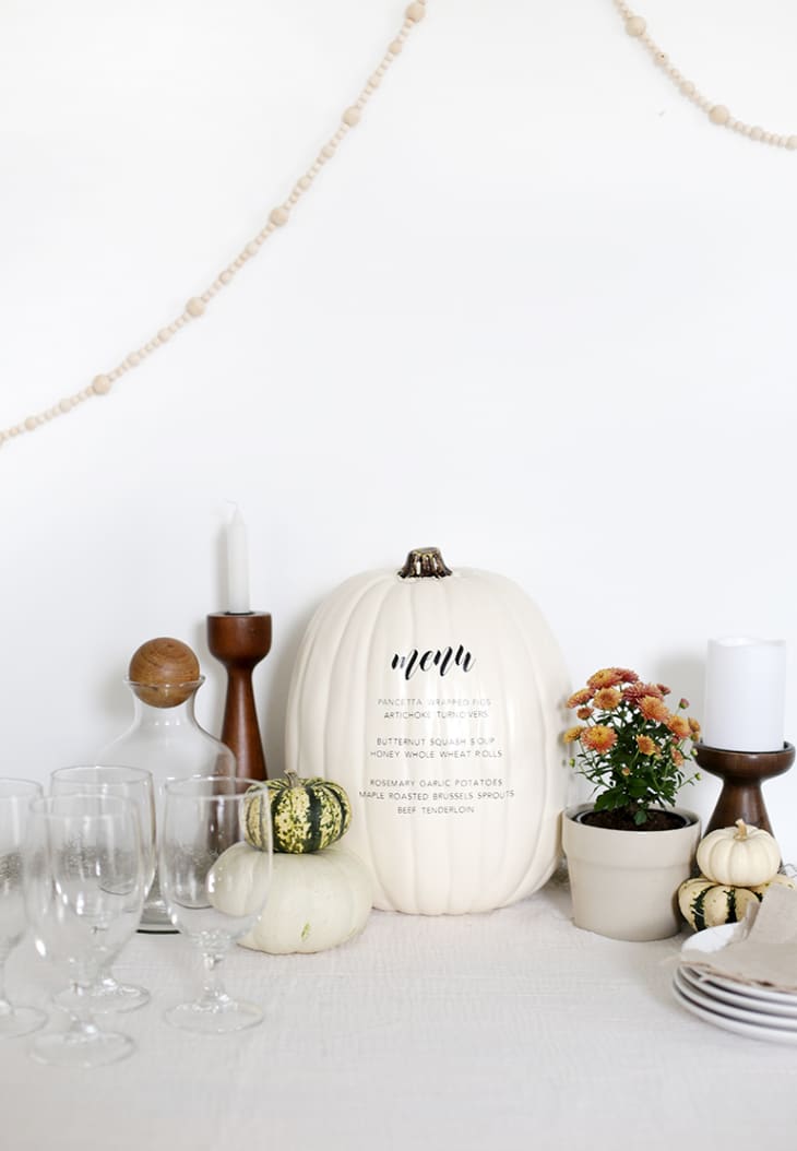 A white decorative pumpkin on a counter