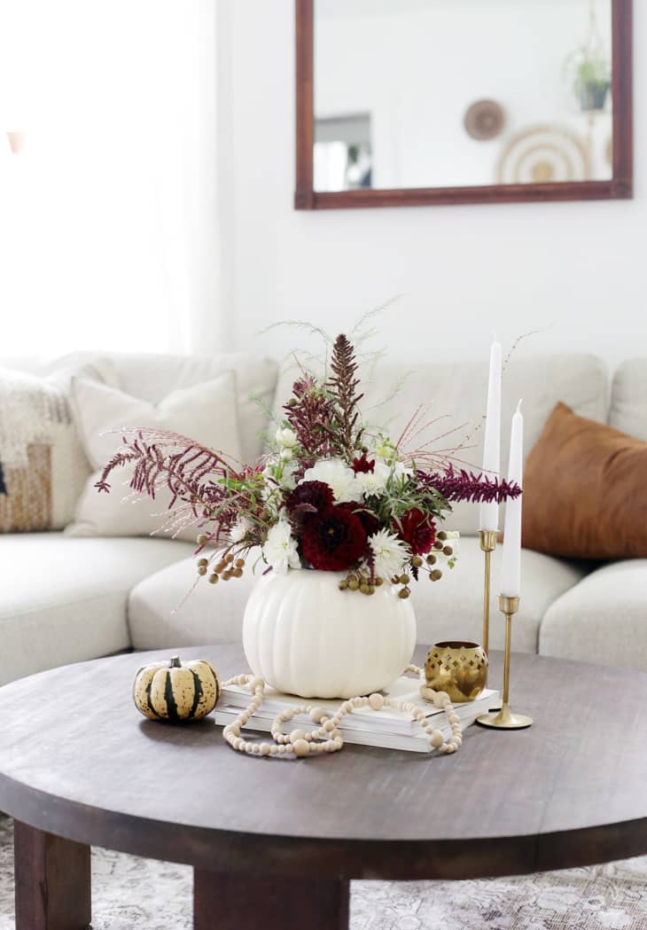A white pumpkin vase with dried flowers