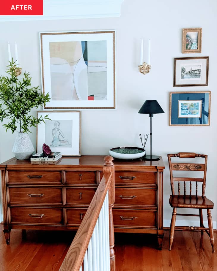 After: a wall with framed art and a wooden table next to a chair