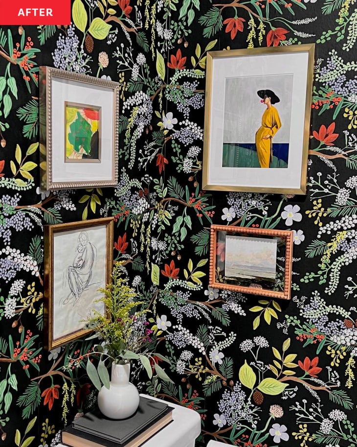 After: the corner of a bathroom wall with framed art on jungle leaf wallpaper