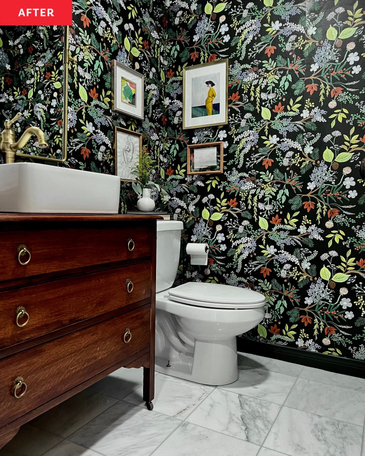 After: a bathroom with black wallpaper with green jungle leaves