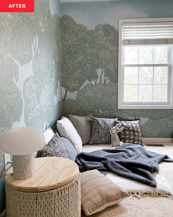 After: a room with forest wallpaper and pillows on the floor