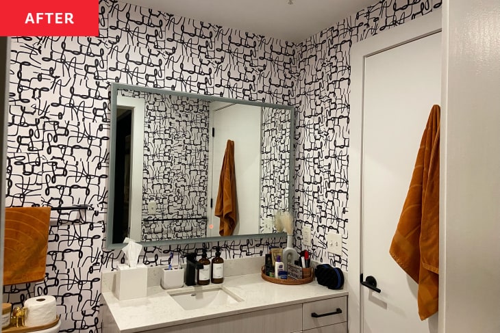 After: A black and white bathroom wall with a large mirror above the sink