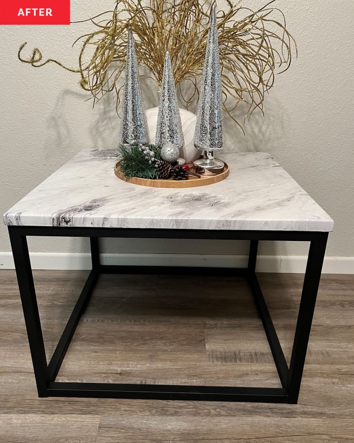 After: Table with marble top and sleek black legs with Christmas decor on it