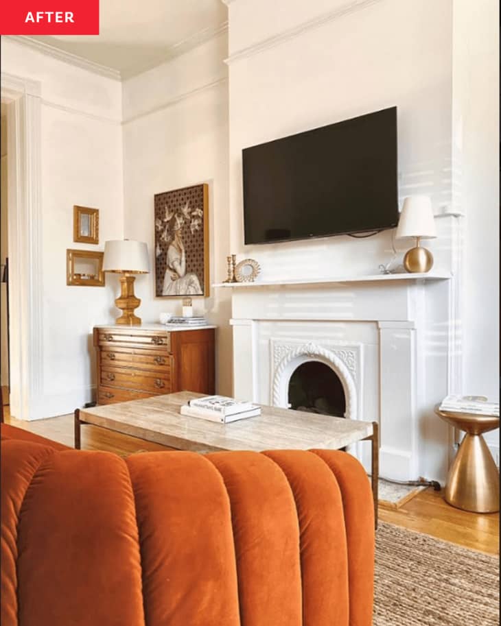 After: a white living room with an orange velvet couch facing a tv over a fireplace