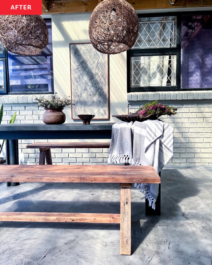 After: an outdoor dining table next to a white brick wall