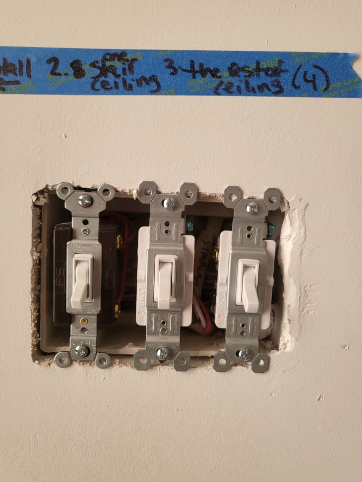 Light switches on a wall without the switch plate