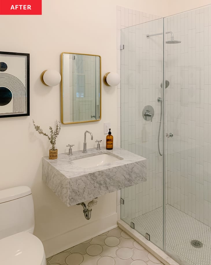 White bathroom with marbled sink vanity after renovations.