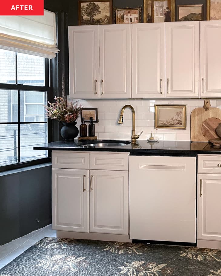 Kitchen cabinets painted white and walls painted dark color in renovated kitchen.