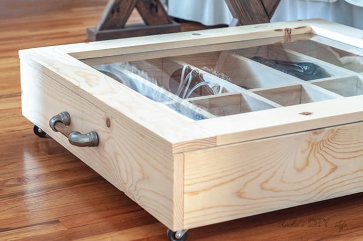 A rolling under-the-bed shoe organizer made from wood and plexiglass.