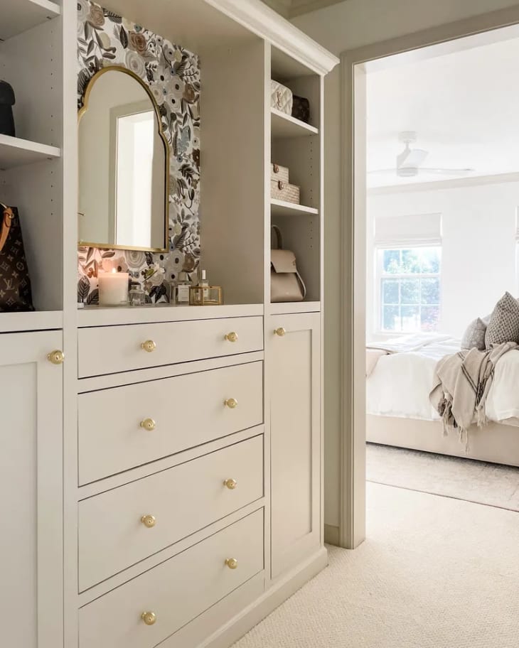 A built-in dresser in the hallway of a home features open shelves, cabinets, and drawers.