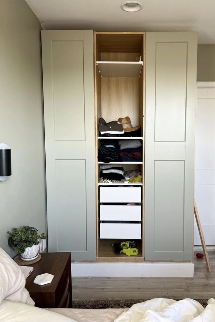 A closet with three door panels, but the middle one is open with no door.