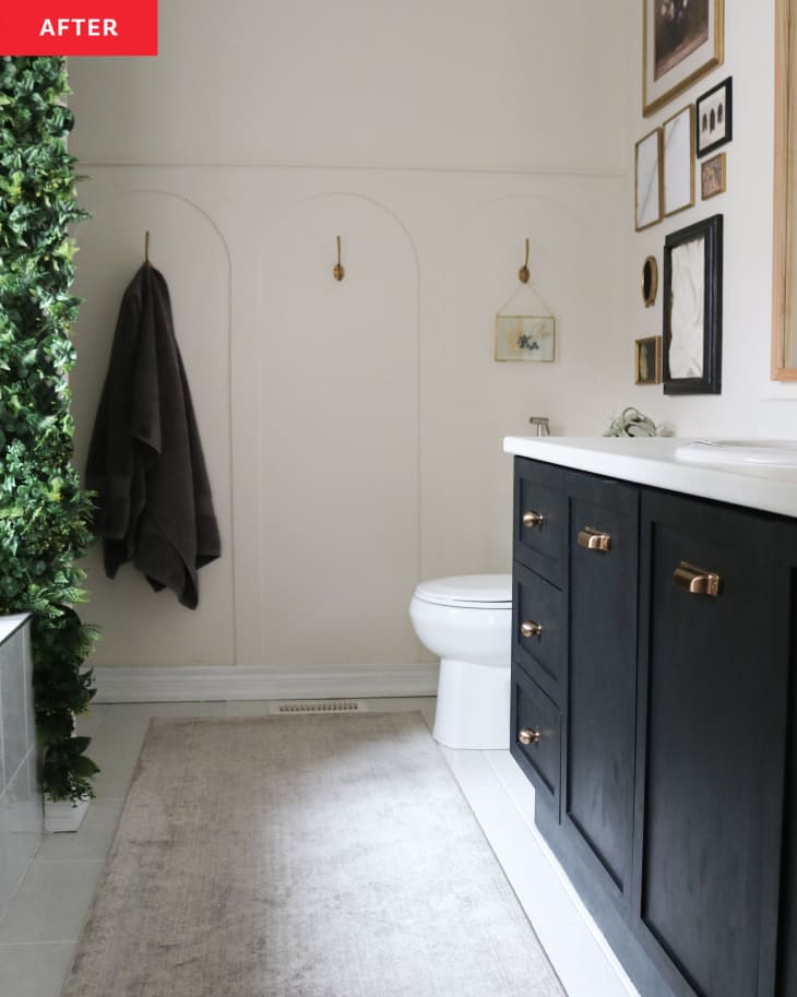 Newly renovated bathroom with black wooden vanity and towel hanging on rack