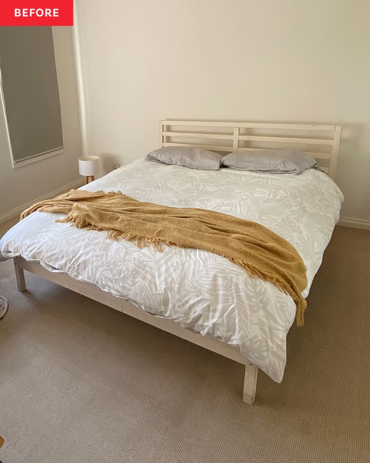 Bed with white linens and tan or yellow throw blanket on top of bed before renovation.