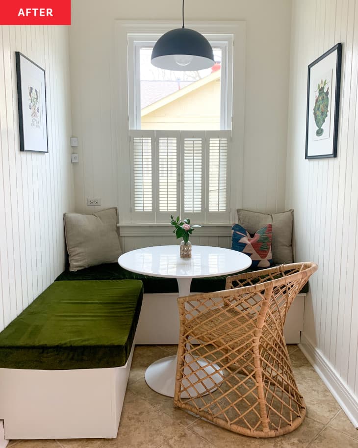 Dining nook after renovating, DIY bench added. white round table, green cushion on bench with throw pillows, one cane chair, white walls, window
