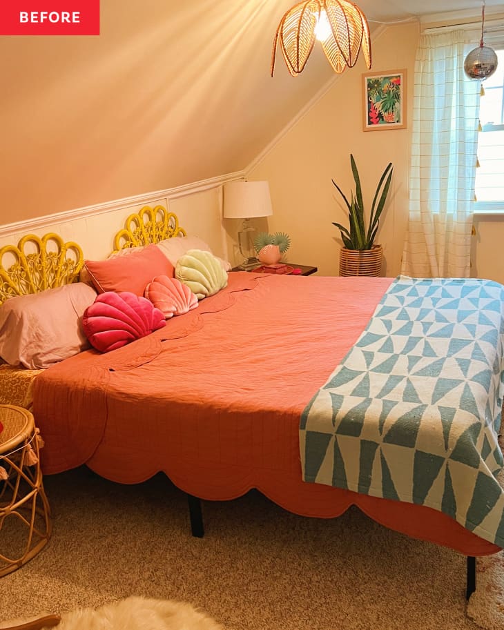 Bedroom before makeover. beige walls and ceiling, cane decorative headboard and bedside table, coral bedspread, snake plant, 3 velvet scallop shell pillows