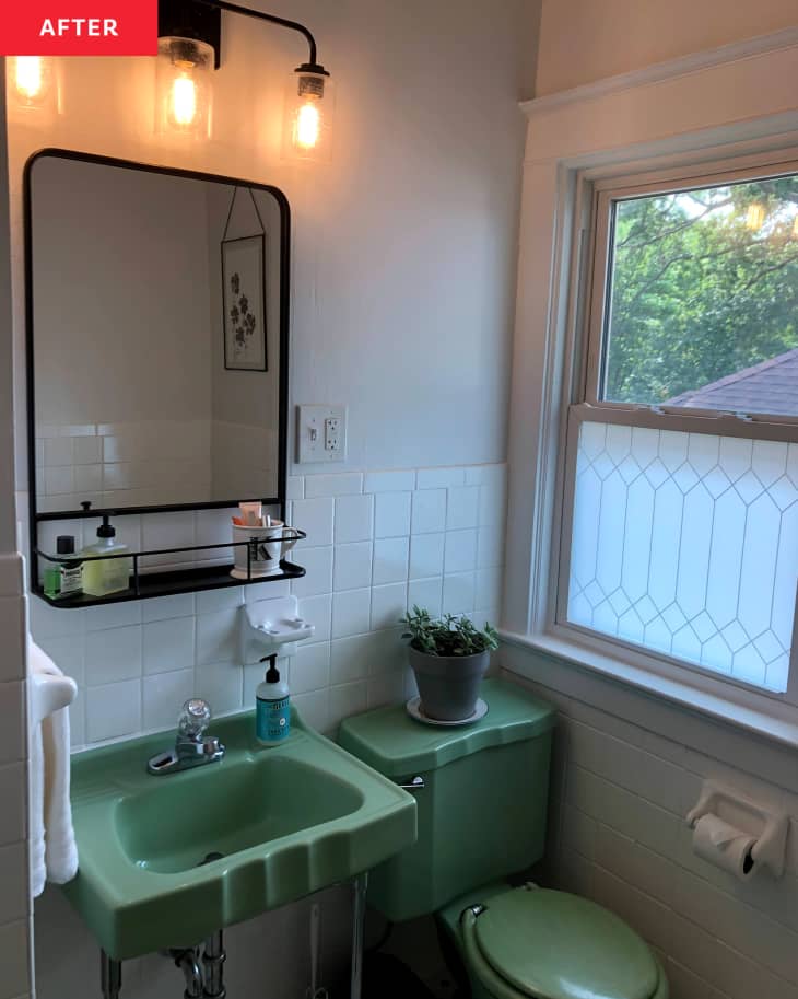 Jade green vanity and toilet in bathroom after the addition of black vanity mirror and scone during renovations.