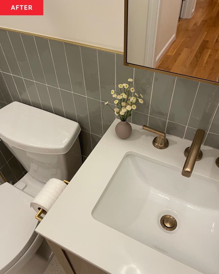 Renovated bathroom with tiled wainscoting and gold faucet hardware.