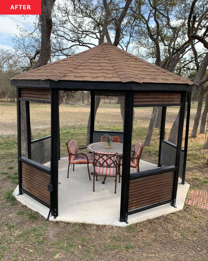 Brown wood with black trimmed gazebo decorated with patio furniture after renovation.
