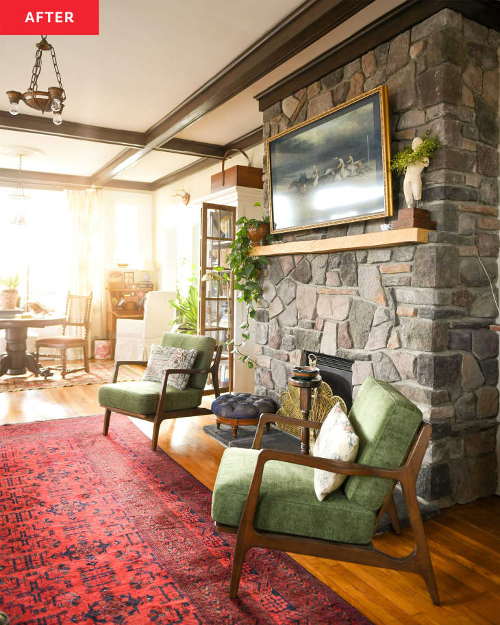 Living room after renovation: fireplace area. Stone fireplace, 2 midcentury style green chairs, red area rug