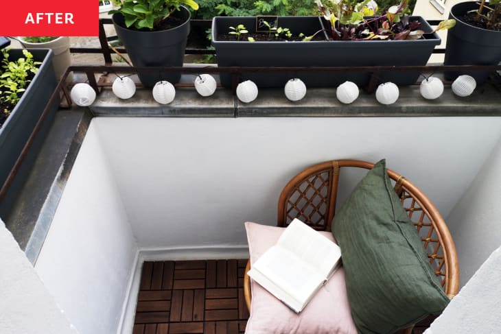 Balcony painted white with string lights and herbs after renovation.